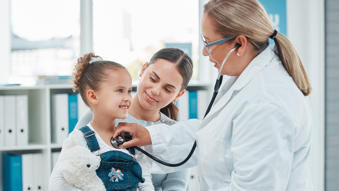 Niño, madre y médico con estetoscopio para examen, revisión pulmonar y atención médica. Madre, niña feliz y pediatra auscultando el tórax para una prueba médica, latidos cardíacos o respiración en el hospital para cardiología.