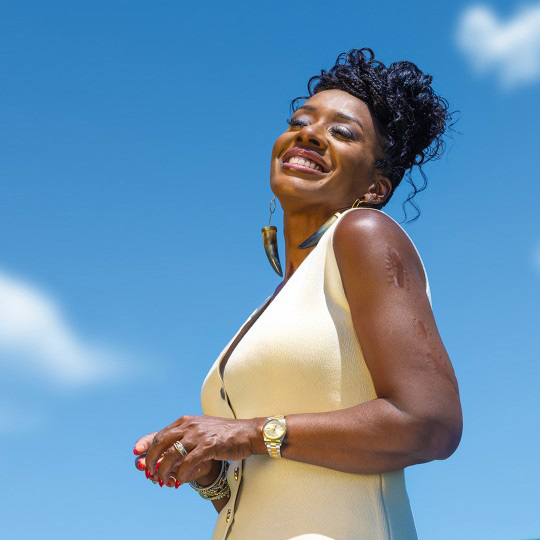 ShantaQuilette in a friendly pose with a sky background