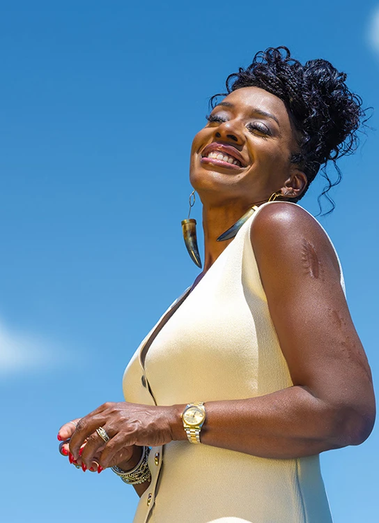 ShantaQuilette in a friendly pose with a sky background