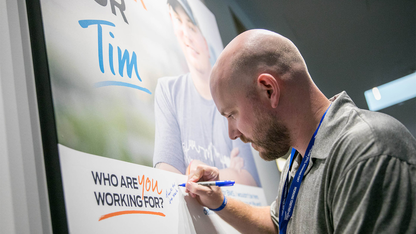 Bristol Myers Squibb invites patient to visit its offices and speak to employees about their health journey. Tim Grimes, part of Global Patient Week 2018, autographs a poster in New Jersey.