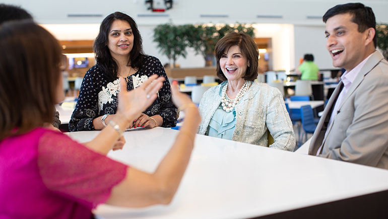 Rita Fawcett (center), of the cardiovascular field team, talks with PAN members, including Manisha Mahimkar (left) and Shalabh Singhal, who helped create training materials that shed light on important cultural insights.