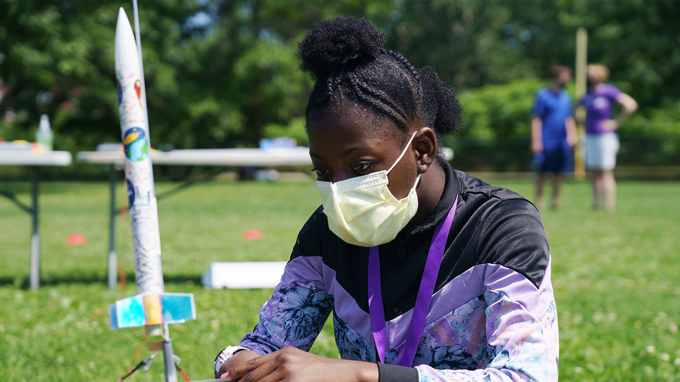 Science Club for Girls scientist, Jhianna examining her rocket before its launch