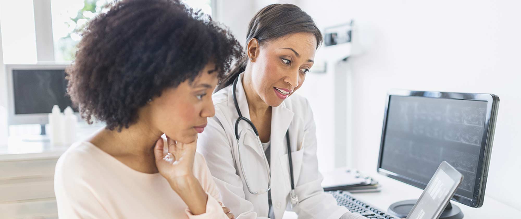 A doctor and patient in office reviewing results on a monitor