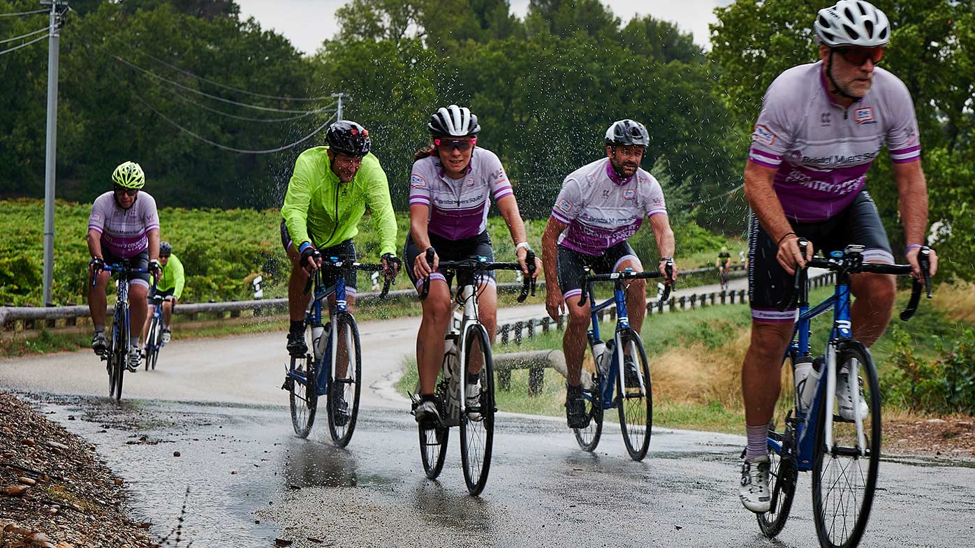 Group of Cyclists Riding Through Rain