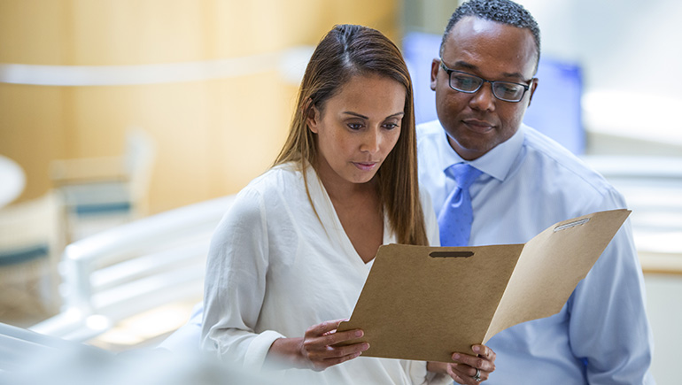 Co-workers looking at documentation