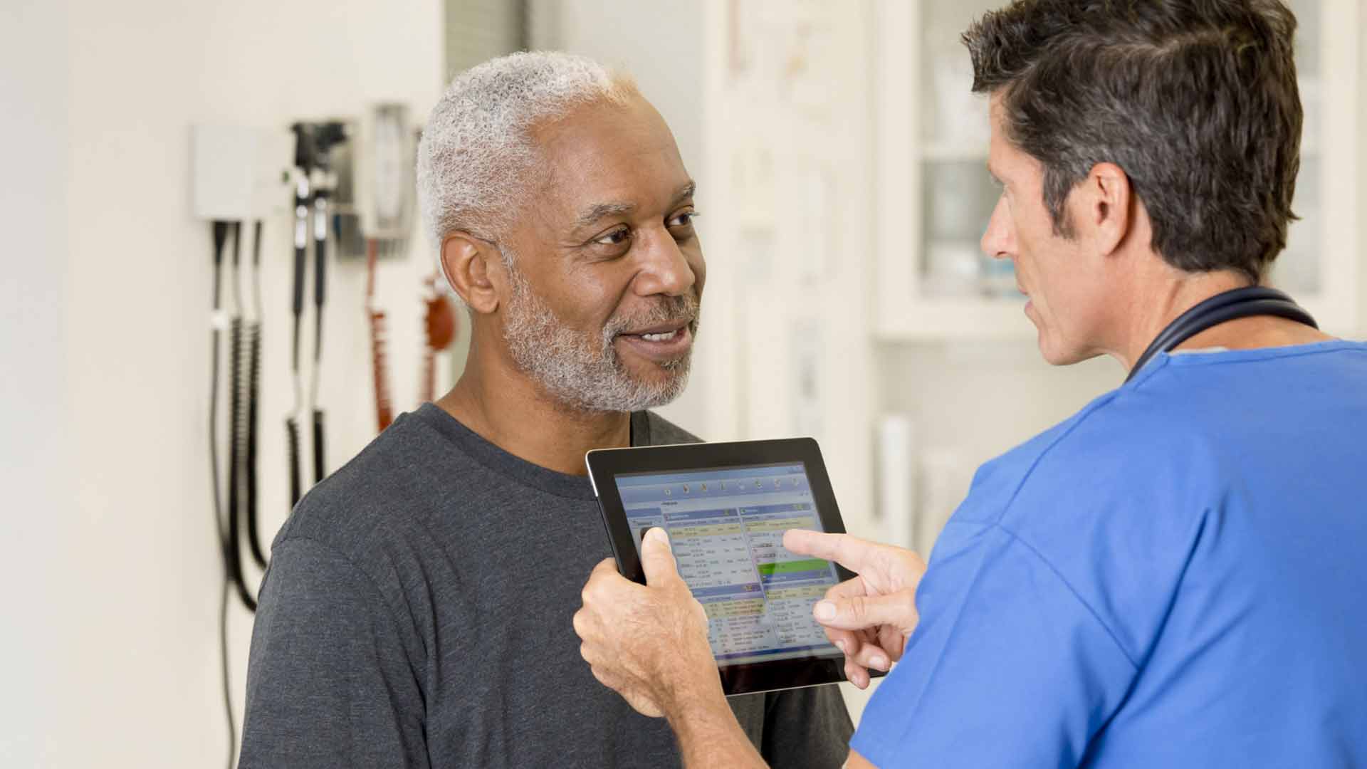 Doctor using tablet while discussing options with patient