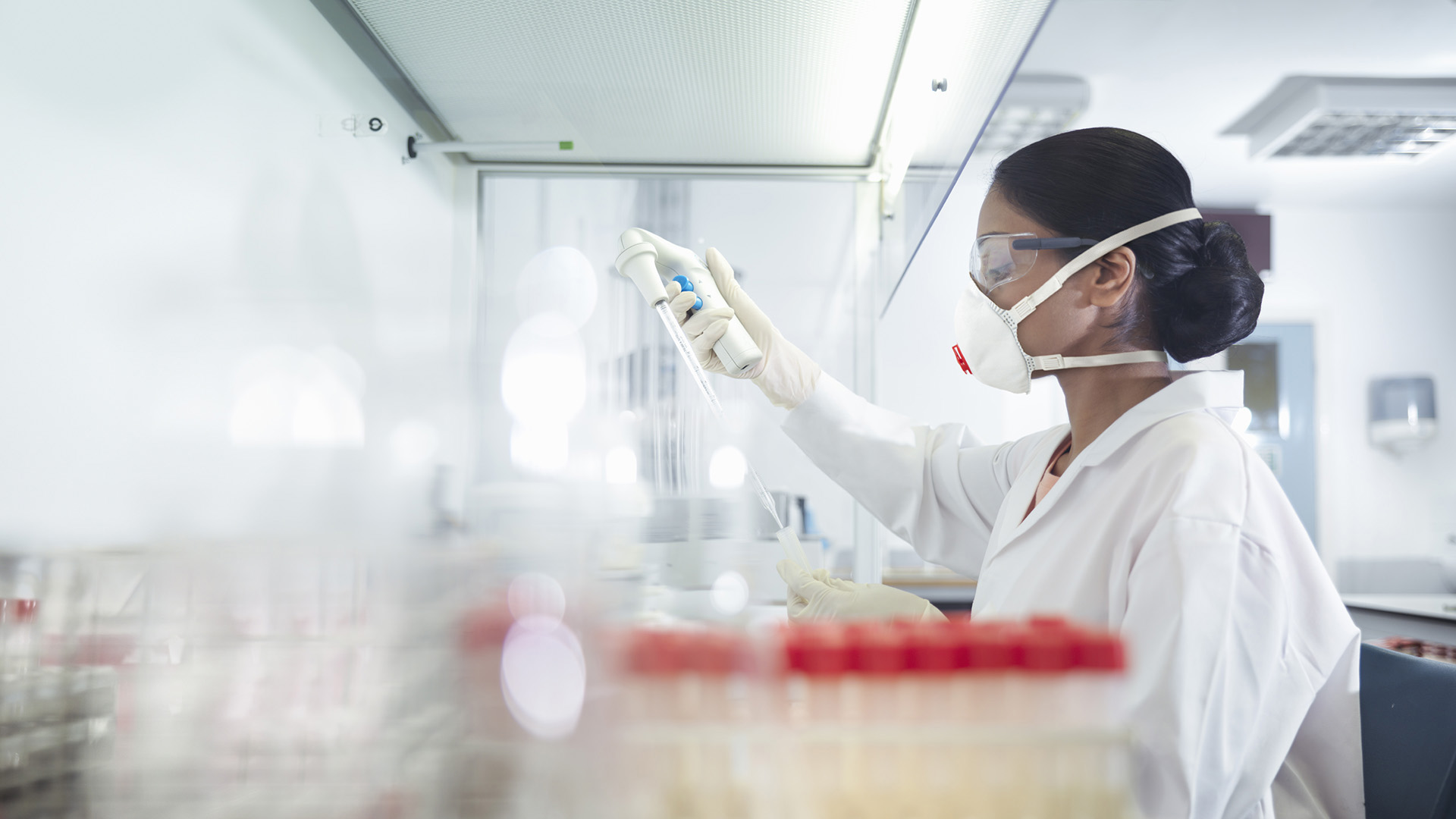 Woman scientist in lab working with syringe