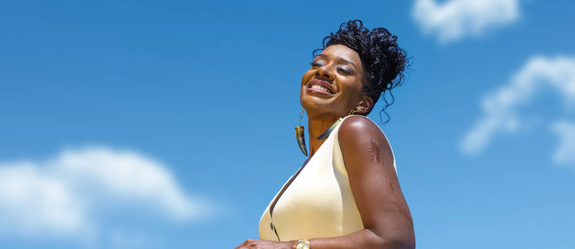 ShantaQuilette in a friendly pose with a sky background