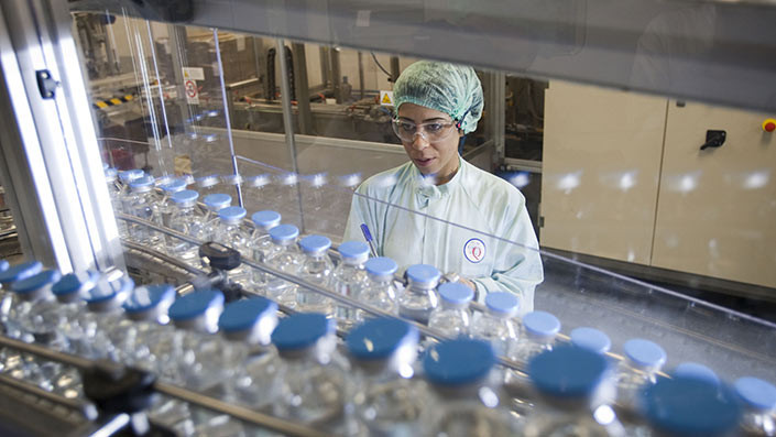 Scientist observing rows of vials