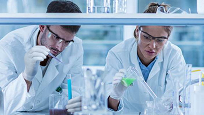 Twee wetenschappers vullen medicijnflesjes 